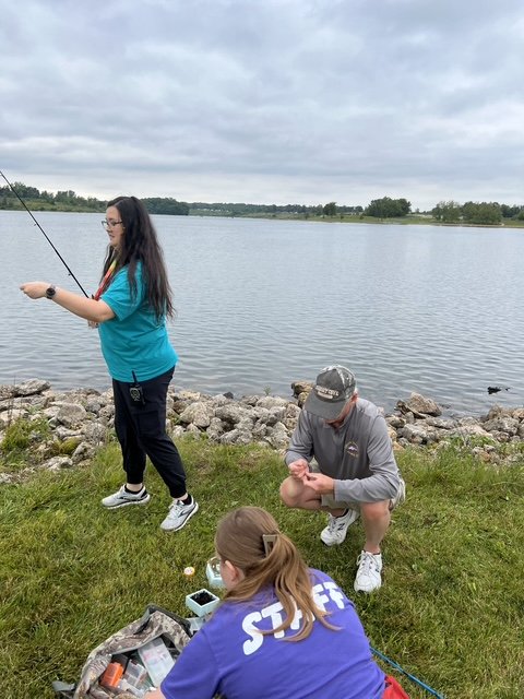 Camp Courageous Fisheree scene with anglers and volunteers