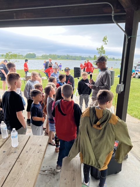 Volunteer helping a young angler at the Fisheree (gallery view)